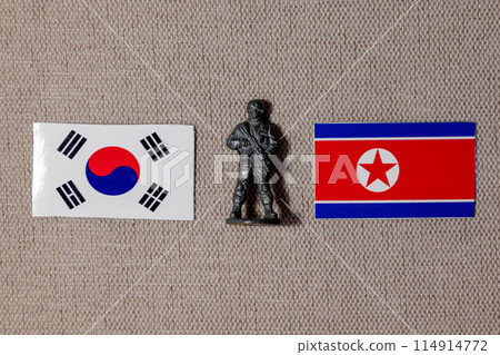 A soldier figurine on the background of the flags of North Korea and South Korea 114914772