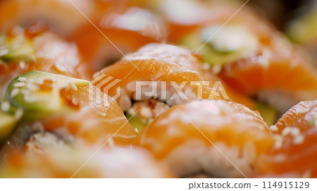 Close-up sushi highlighting fresh fish, avocado, and rice textures. 114915129