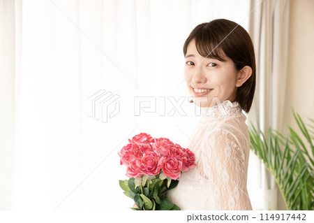 拿著一束紅玫瑰的微笑的女人 114917442