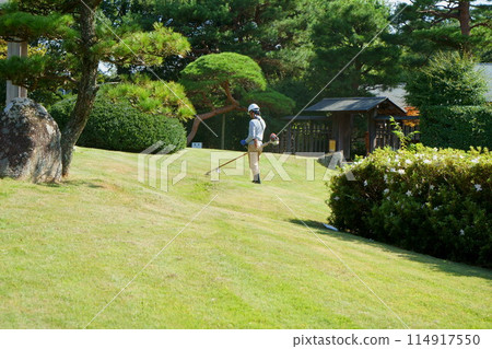 一位工匠在日本花園裡修剪草坪 114917550