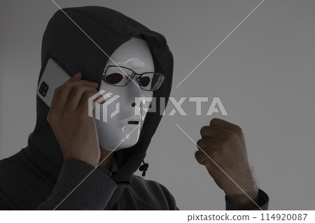 A man wearing a white mask and glasses making a phone call. Clenched fist 114920087