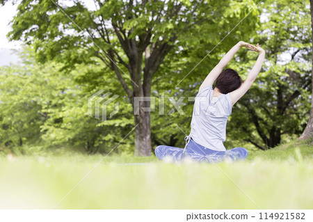 Back view of a young woman stretching outside Outdoor yoga image 114921582