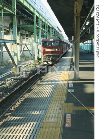 清晨陽光下穿過車站的貨運列車（遠處） 114922753