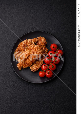Delicious fresh crispy chicken nuggets on a dark concrete background 114923387