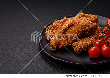 Delicious fresh crispy chicken nuggets on a dark concrete background Delicious fresh crispy chicken nuggets on a dark concrete background 114923388
