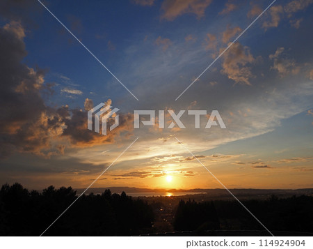 Sunset on the opposite shore of Lake Inawashiro. The orange clouds and the sparkling lake surface are impressive and beautiful against the blue sky. 114924904