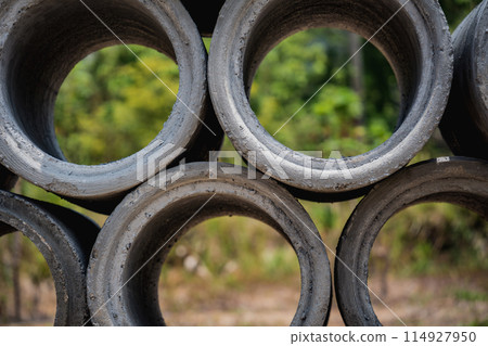 A stack of concrete ring pipes piled and creating a symmetrical arrangement 114927950