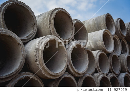 A stack of concrete ring pipes piled and creating a symmetrical arrangement A stack of concrete ring pipes piled and creating a symmetrical arrangement 114927959