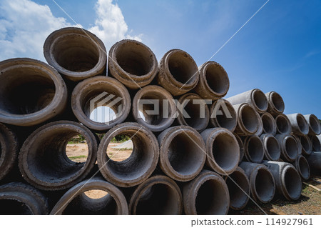 A stack of concrete ring pipes piled and creating a symmetrical arrangement 114927961