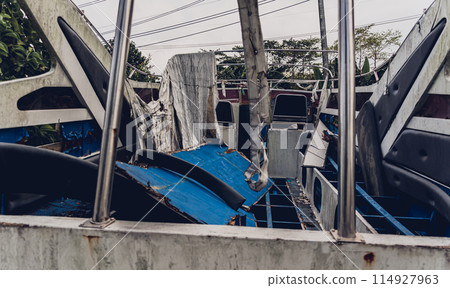 Old and rusty motor boats on a landfill surrounded by tropical forest 114927963