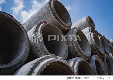 A stack of concrete ring pipes piled and creating a symmetrical arrangement 114927984