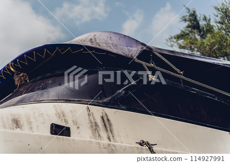 Old and rusty motor boats on a landfill surrounded by tropical forest Old and rusty motor boats on a landfill surrounded by tropical forest 114927991