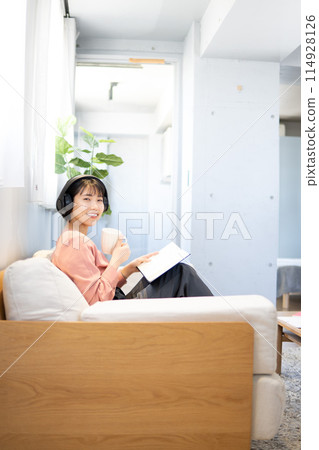 A woman reading while listening to music/Reskilling A woman reading while listening to music/Reskilling 114928126