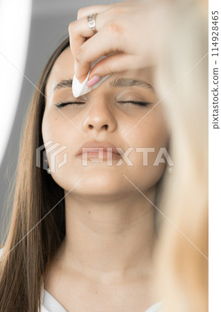 This photo fragment shows how the beautician carefully examines the features of the face and selects the best option for eyebrow correction. The result is expressive and individual. This photo fragment shows how the beautician carefully examines the features of the face and selects the best option for eyebrow correction. The result is expressive and individual. 114928465