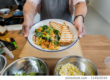 Chef at the kitchen preparing tofu scramble with vegetables Chef at the kitchen preparing tofu scramble with vegetables 114928584