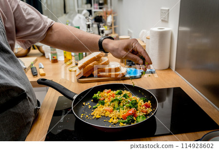 Chef at the kitchen preparing tofu scramble with vegetables 114928602
