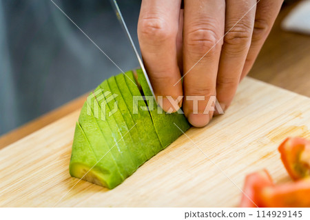 Chef at the kitchen preparing healthy quinoa bowl with avocado 114929145