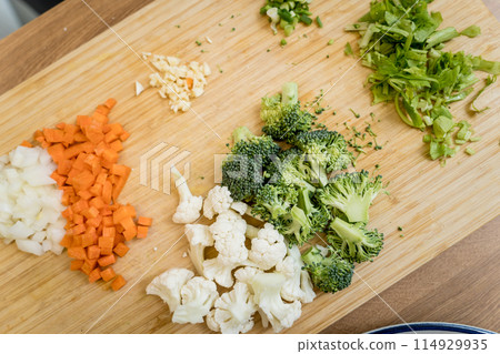 Cutting board with ingredients for preparing lentils soup with cauliflower and broccoli Cutting board with ingredients for preparing lentils soup with cauliflower and broccoli 114929935