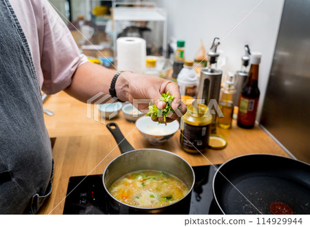 Chef at the kitchen preparing lentils soup with cauliflower and broccoli Chef at the kitchen preparing lentils soup with cauliflower and broccoli 114929944