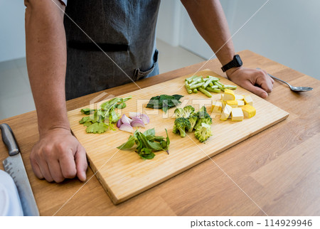Chef at the kitchen preparing green curry with herbs and rice Chef at the kitchen preparing green curry with herbs and rice 114929946