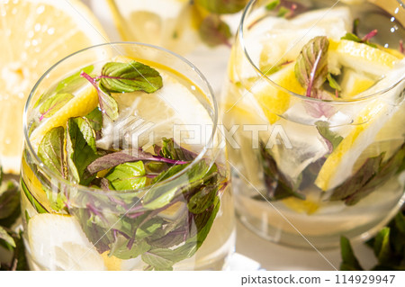 Lemonade in glass glasses with lemons and mint Lemonade in glass glasses with lemons and mint 114929947