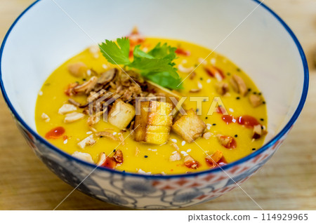 A bowl of pumpkin porridge with tofu and vegetables A bowl of pumpkin porridge with tofu and vegetables 114929965