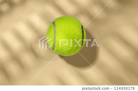 Tennis ball on sandy surface 114930178