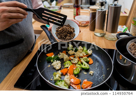 Chef at the kitchen preparing japanese buckwheat pasta with lentils Chef at the kitchen preparing japanese buckwheat pasta with lentils 114930764