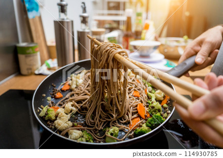 Chef at the kitchen preparing japanese buckwheat pasta with lentils 114930785