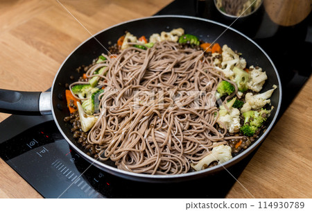 Chef at the kitchen preparing japanese buckwheat pasta with lentils 114930789