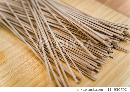 Cutting board with raw japanese buckwheat pasta Cutting board with raw japanese buckwheat pasta 114930792