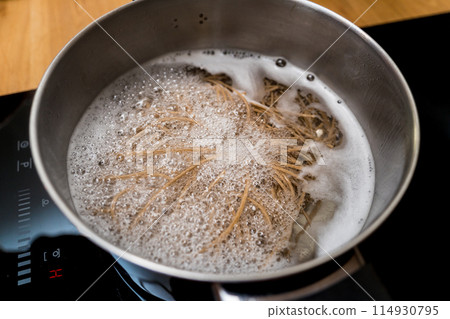 Chef at the kitchen preparing japanese buckwheat pasta with lentils 114930795