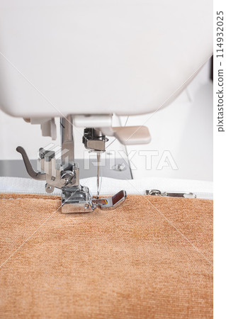 Modern sewing machine special presser foot with beige fabric and zipper, closeup Modern sewing machine special presser foot with beige fabric and zipper, closeup 114932025