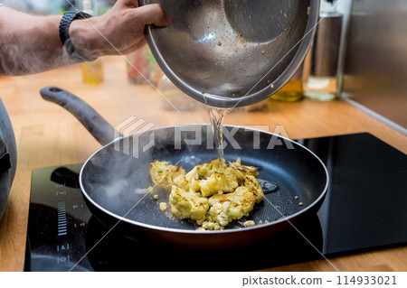 Chef at the kitchen preparing bean porridge with cauliflower and vegetables 114933021
