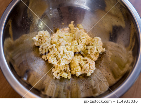 Chef at the kitchen preparing bean porridge with cauliflower and vegetables 114933030