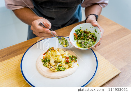 Chef at the kitchen preparing bean porridge with cauliflower and vegetables Chef at the kitchen preparing bean porridge with cauliflower and vegetables 114933031