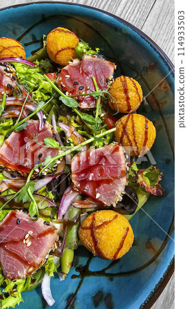 Salad with tuna and cheese balls topped with soy sauce. Fast and healthy food. 114933503