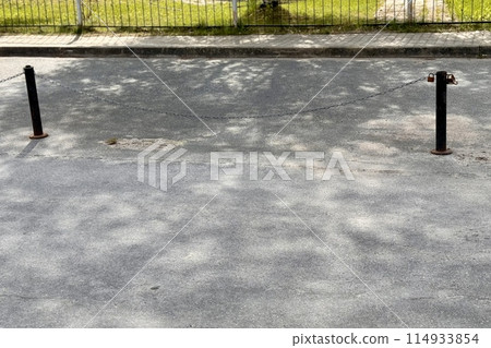 Metal restraints with an iron chain with a key for parking a car between poles outdoors in a special area on a summer day 114933854