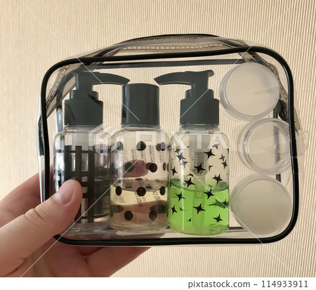 Unknown man is holding a transparent trunk filled with bottles for hygiene products for a business trip. Close-up 114933911