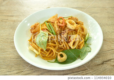 spicy stir fried spaghetti slice squid with chili and basil leaf in sauce on plate  114934010