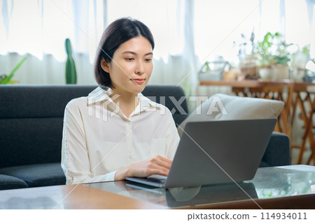 年輕女子在房間裡操作電腦 114934011