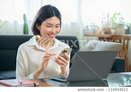 年輕女子在房間裡操作電腦 114934012