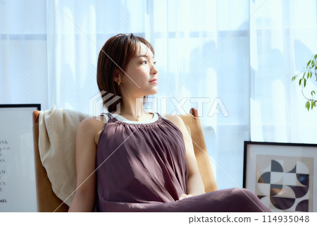 Sit in a chair in your room and relax in the morning sunshine 114935048