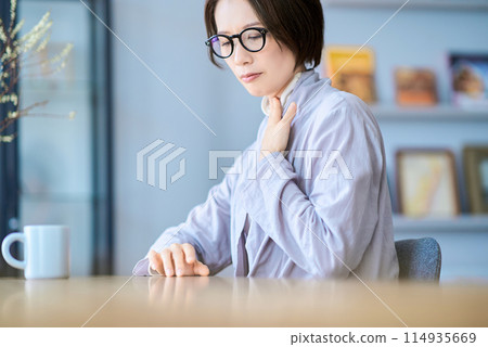 A woman who seems to have a strange feeling in her throat 114935669