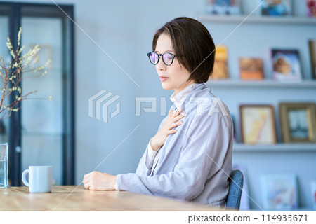 A woman who seems to have a strange feeling in her throat 114935671