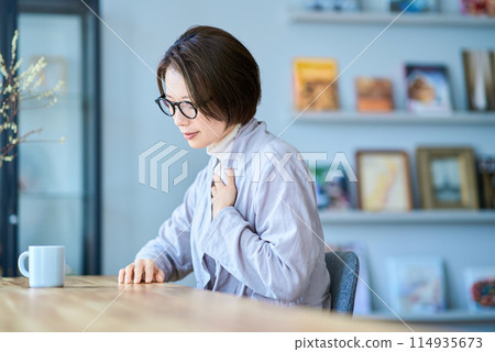 一名女性似乎感覺喉嚨不舒服 一名女性似乎感覺喉嚨不舒服 114935673