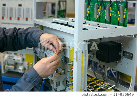 worker assembling electrical equipment in a factory worker assembling electrical equipment in a factory 114936649