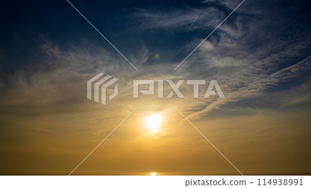 The setting sun and flowing clouds in the evening sky 114938991