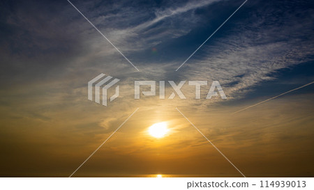 The setting sun and flowing clouds in the evening sky 114939013