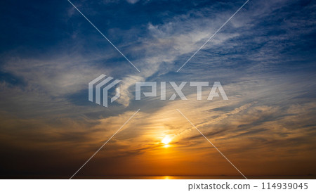The setting sun and flowing clouds in the evening sky The setting sun and flowing clouds in the evening sky 114939045